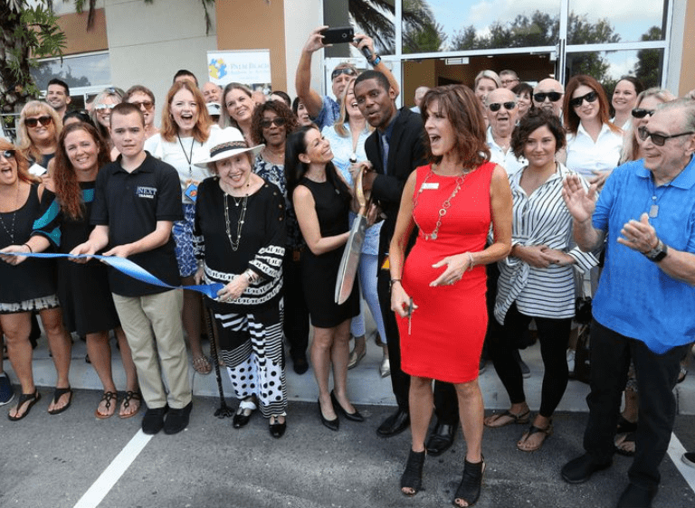 Ann Eisenberg, Executive Director of Palm Beach School for Autism, center in red, cuts the ceremonial ribbon with students, parents, donors and dignitaries at the Palm Beach School for Autism in Lake Worth on Wednesday, Sept. 18, 2019. The school unveiled a new 10,000-square-foot kitchen extension, classroom, mock hotel room and more for culinary and hospitality students with autism.