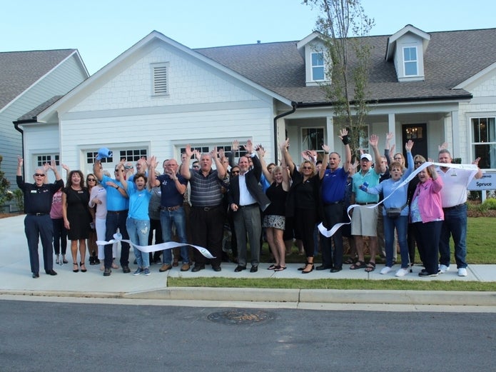 community of group celebrating in front of a home