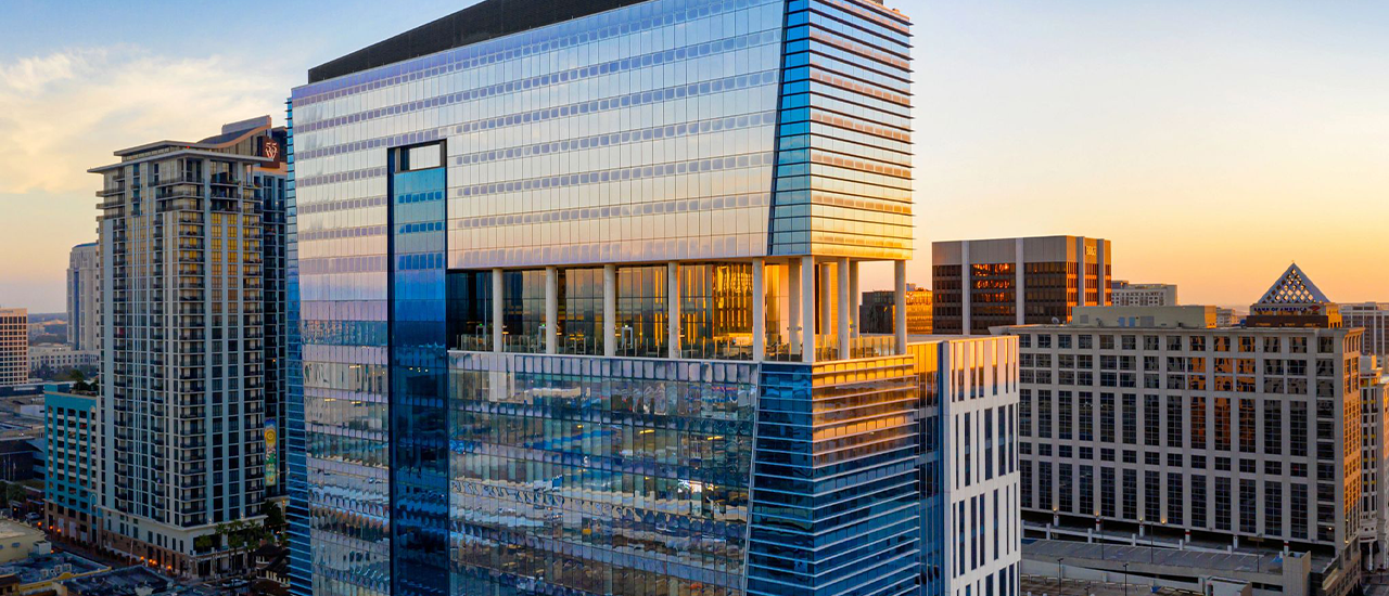 Illuminated hotel towers along Las Olas Boulevard in Fort Lauderdale at dusk.